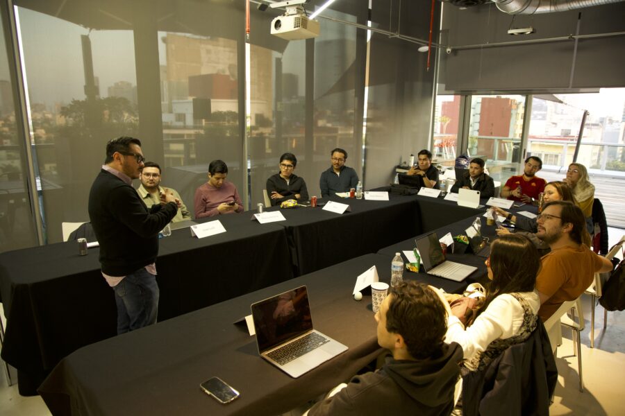 Víctor Alvarado dirigiendo una sesión de trabajo con un grupo alrededor de una mesa