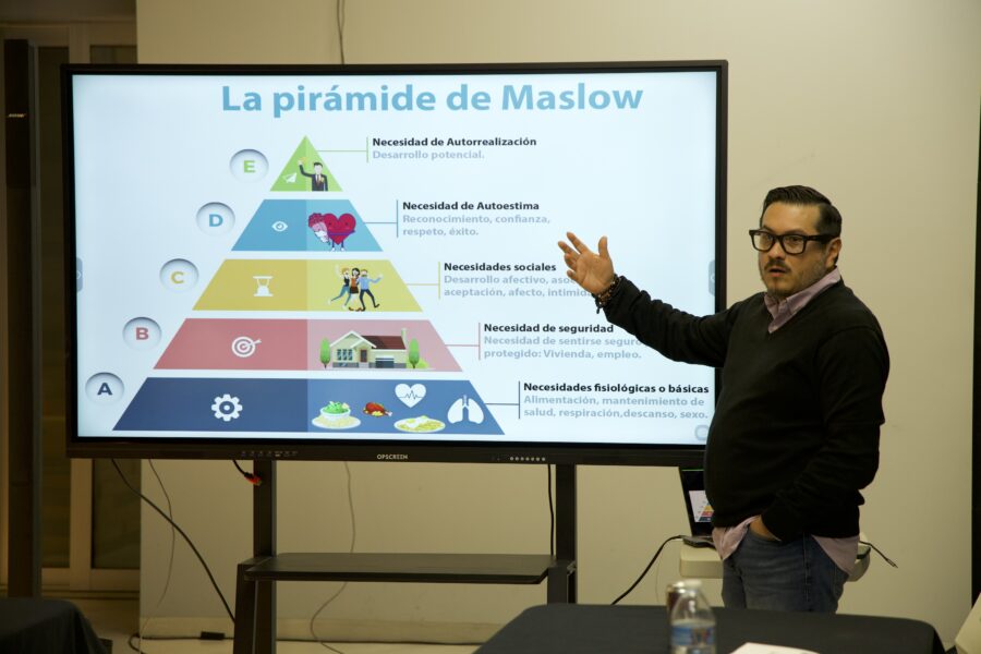 Víctor Alvarado explicando la pirámide de Maslow frente a un grupo
