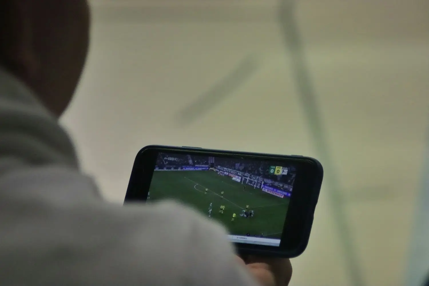 Partido de futbol transmitido en la pantalla de un teléfono